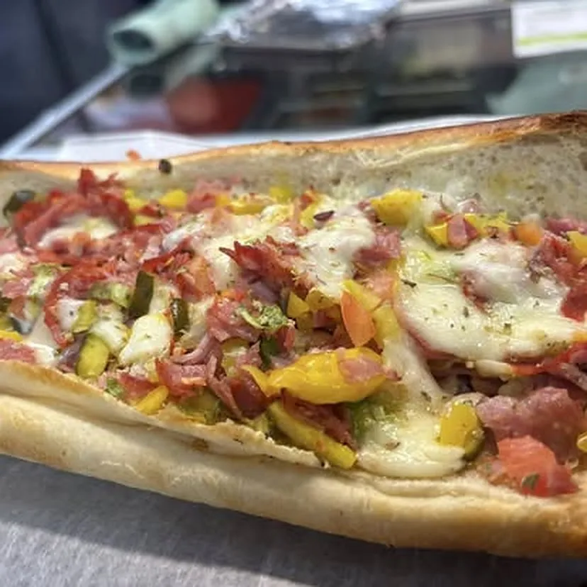 Italian sub piled with provolone, salami, capicola, and ham on a fresh roll